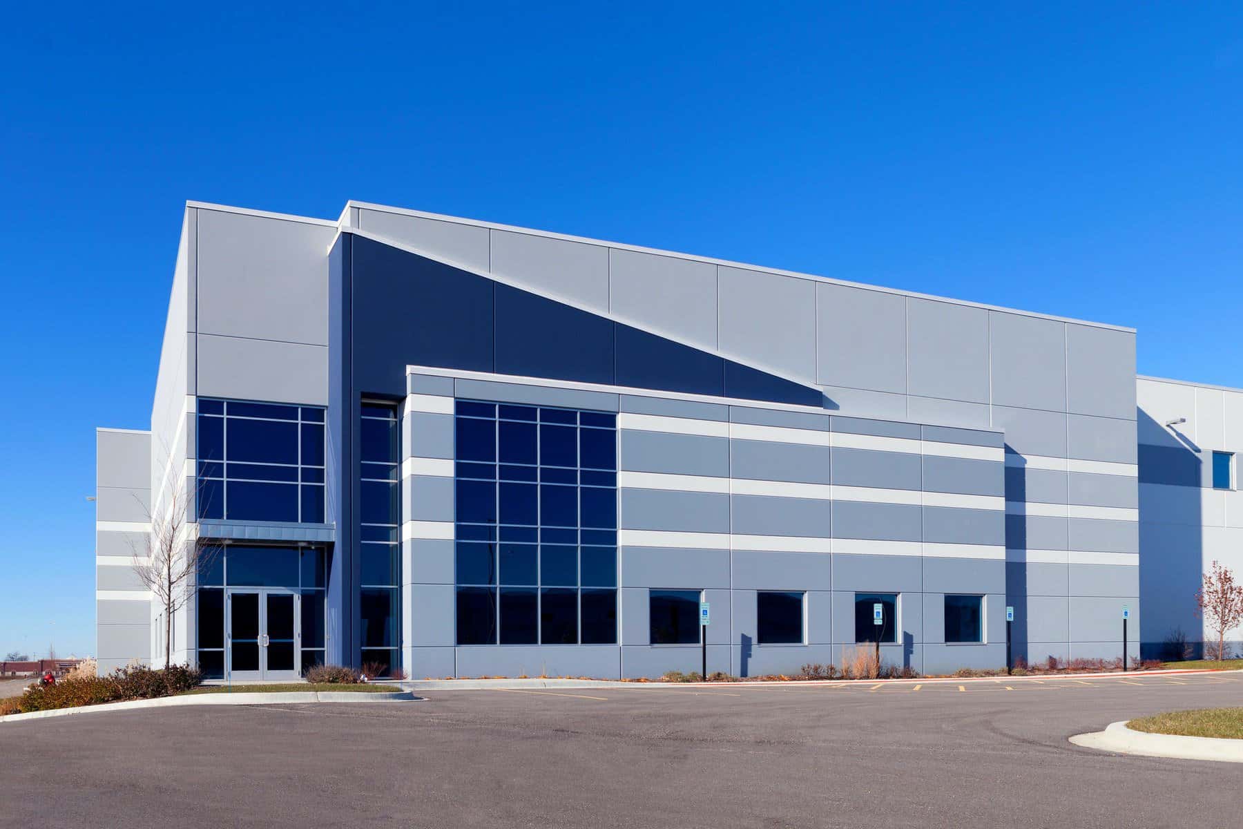 Modern Commercial Building Exterior Light gray and navy blue painted commercial building facade with multi-pane windows and geometric panel design