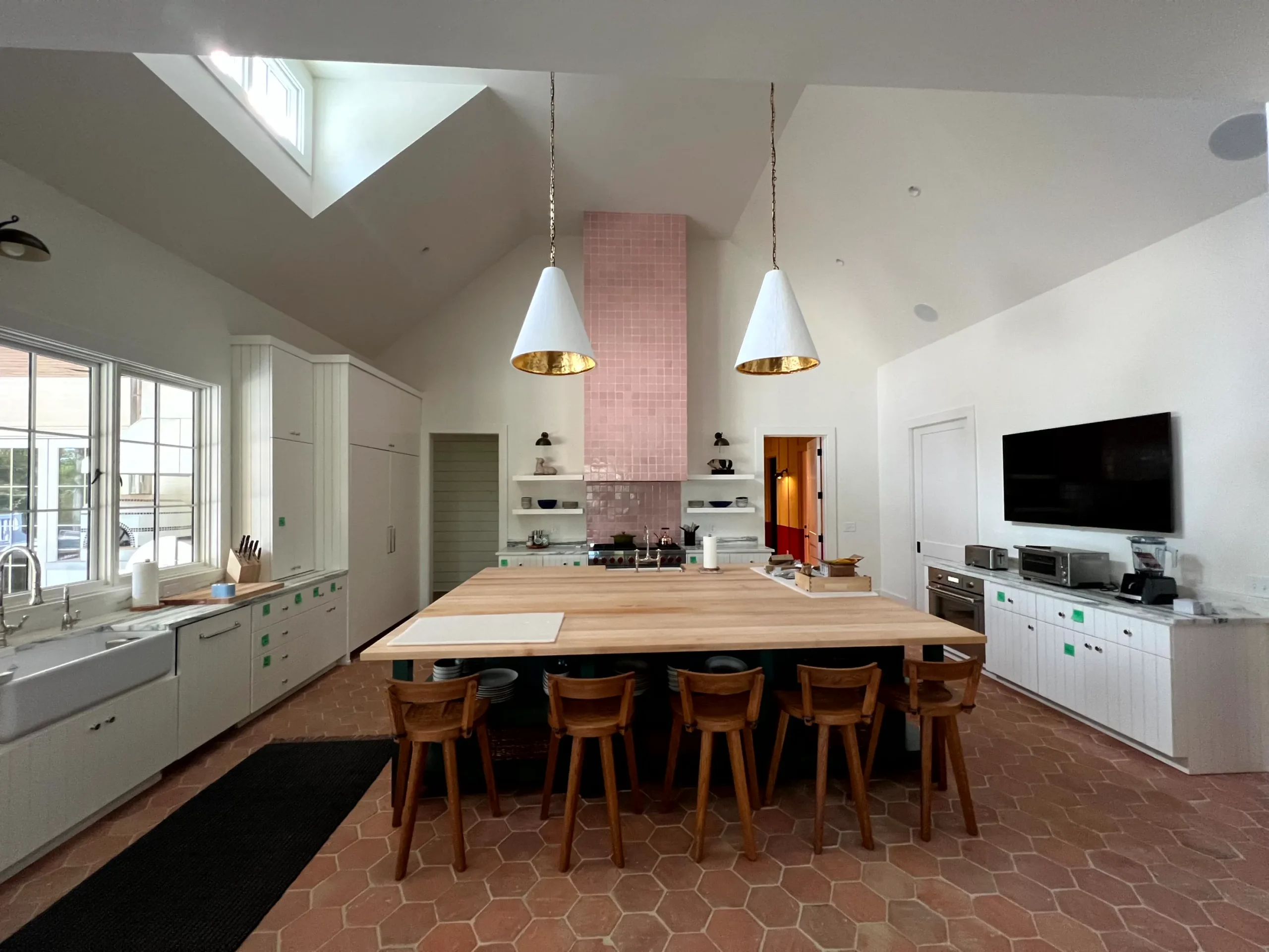 White Vaulted Kitchen Ceiling White painted vaulted ceiling with skylight, pendant lights, and exposed interior residential kitchen in Nashville, Thompson