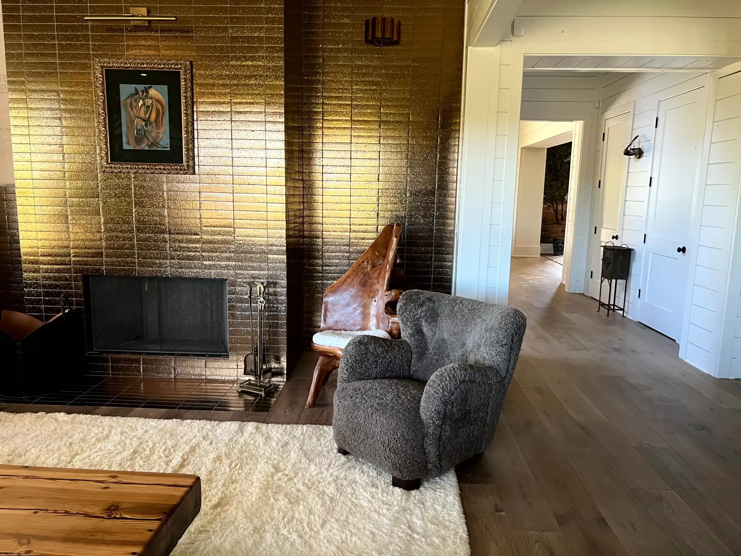 Modern Living Room Interior Painting Bright white-painted interior hallway and living room with dark wood flooring, gold brick fireplace, and white trim doors in