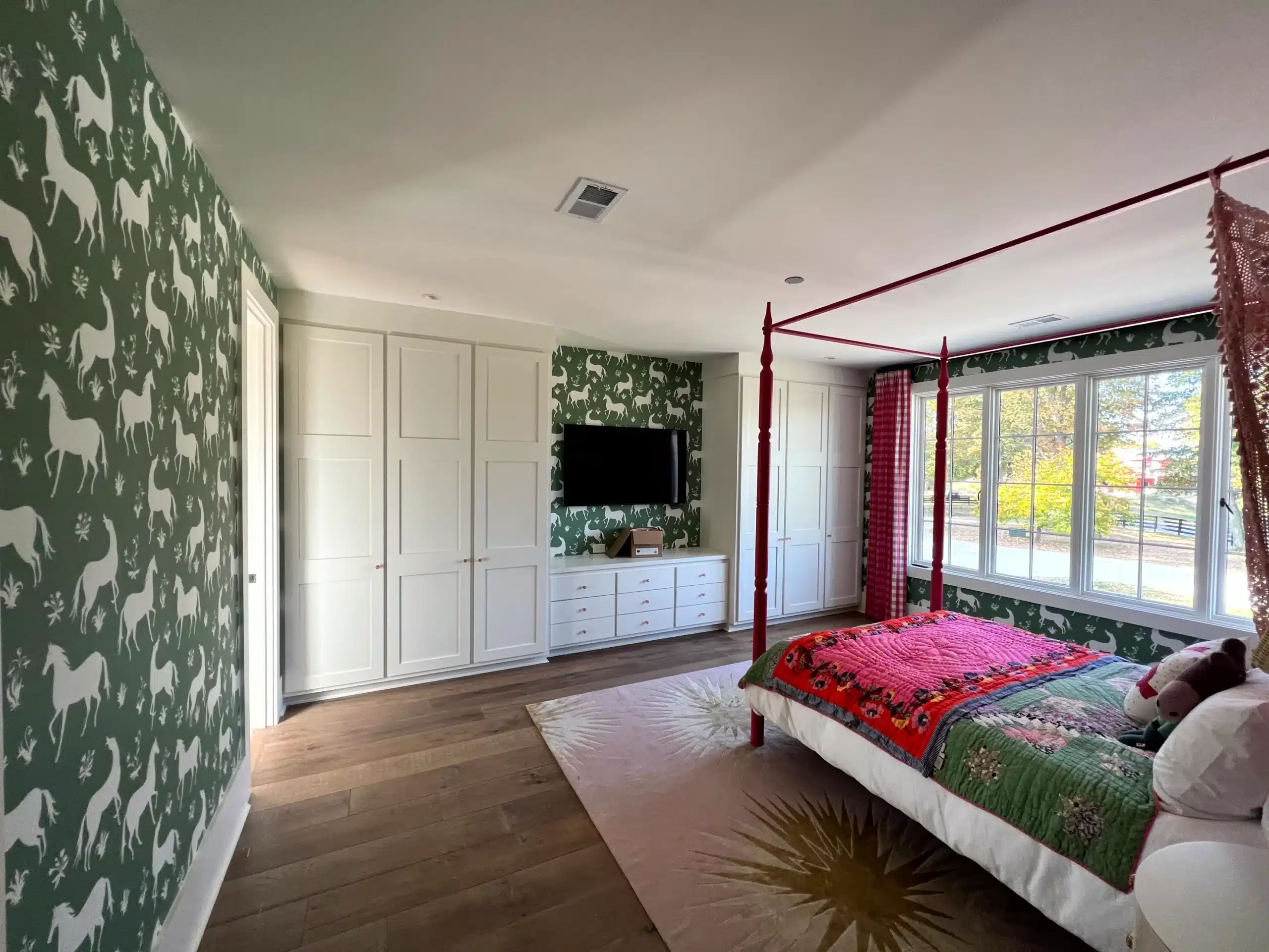 Green Animal Wallpaper Bedroom Green and white animal-patterned wallpaper on bedroom wall with white ceiling, wood flooring, and built-in cabinetry