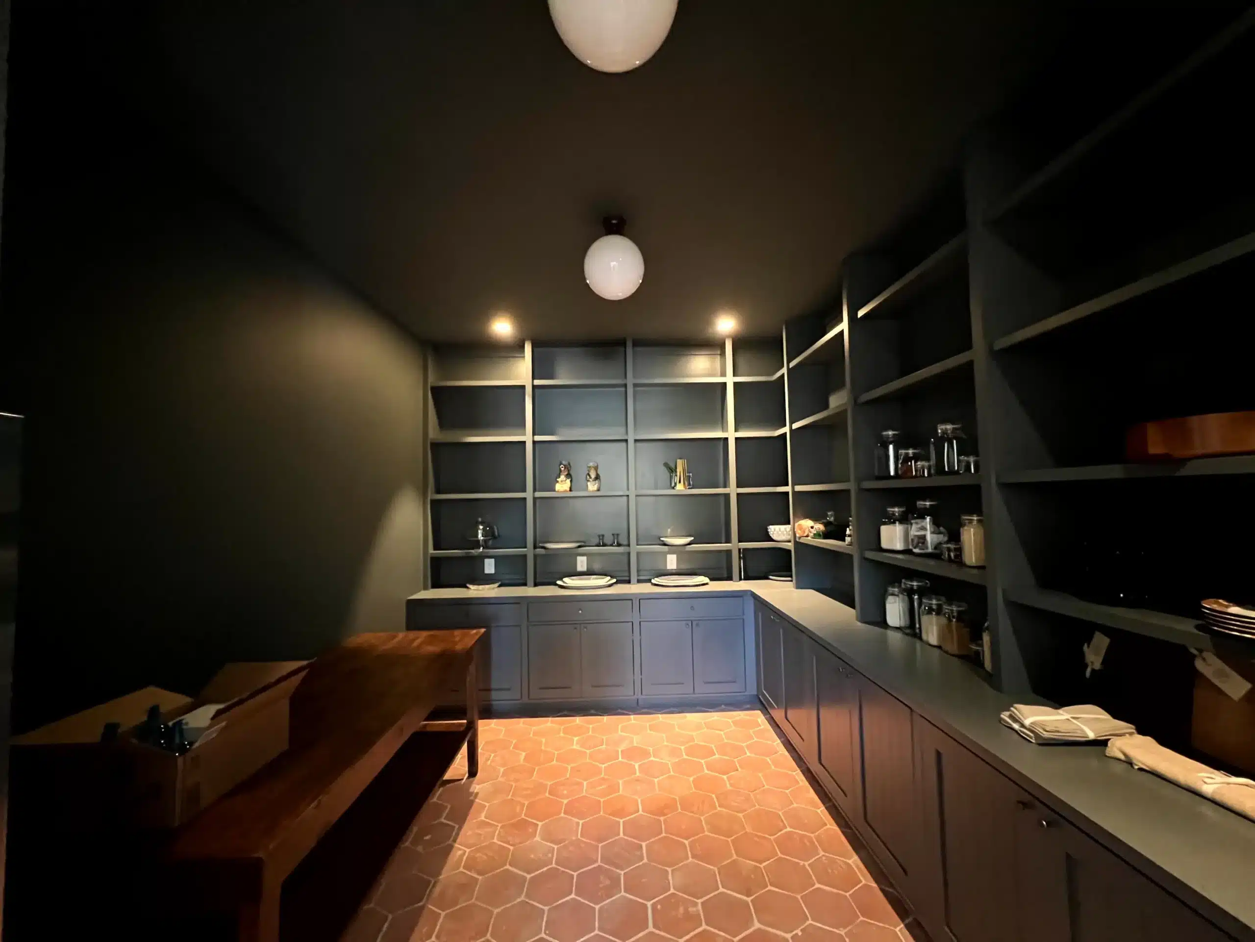 Navy Blue Cabinet Pantry Interior Navy blue painted cabinetry and shelving with warm lighting in residential pantry space in Nashville.