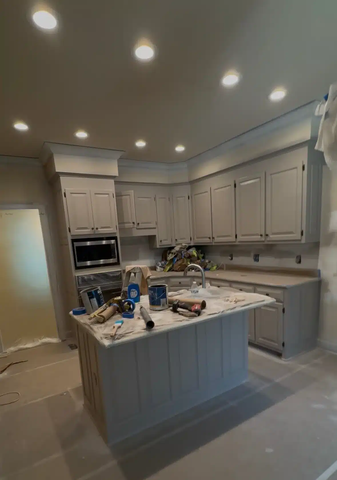 White Cabinet Painting Kitchen White-painted kitchen cabinets and island with recessed ceiling lights during interior residential painting in Nashville