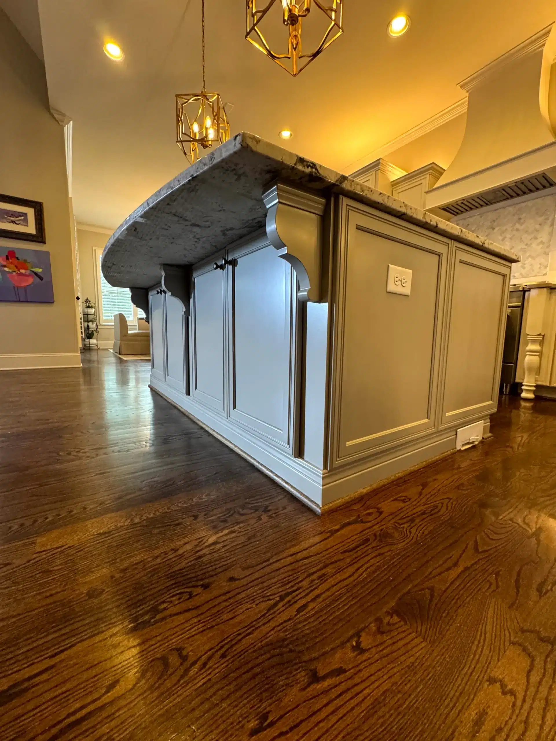 Cream And Light Blue Kitchen Island Cream-painted kitchen island with light blue cabinet doors and dark marble countertop on dark wood flooring.