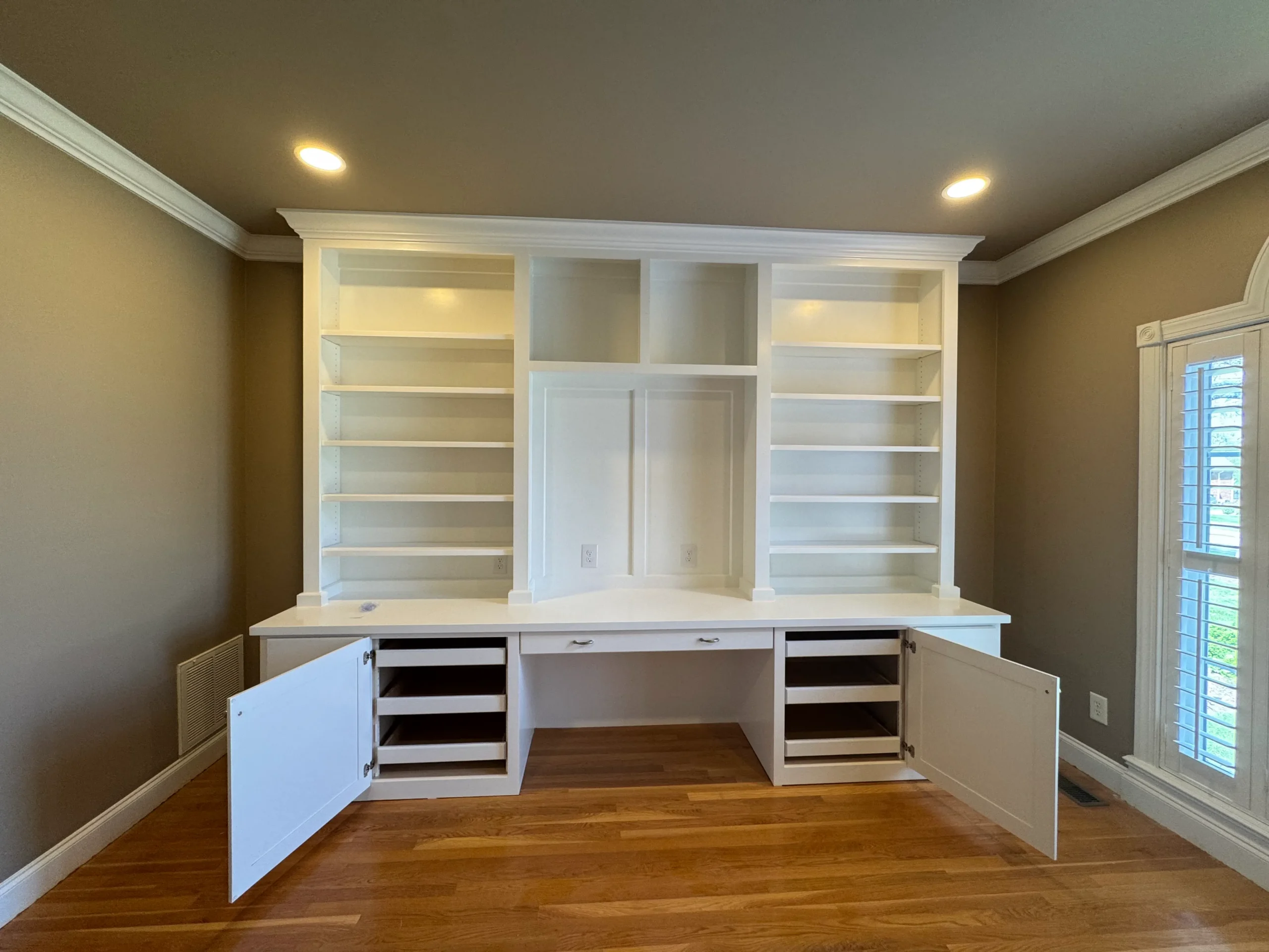 White Interior Cabinet Painting White-painted built-in cabinetry with open shelving, recessed panel doors, and black interior drawers in residential home